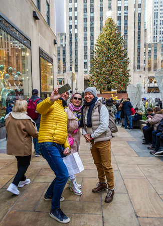 NEW YORK - DECEMBER 5, 2021: Tourists and locals take pictures with Rockefeller Center Christmas Tree in Midtown Manhattanのeditorial素材
