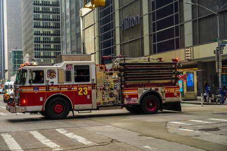 NEW YORK - MARCH 25, 2021: FDNY Engine 23 crossing 6th Avenue in midtown Manhattan. FDNY is the largest combined Fire and EMS provider in the worldのeditorial素材