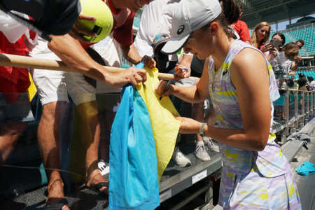MIAMI GARDENS, FLORIDA - APRIL 2, 2022:  Miami Open 2022 Champion Iga Swiatek of Poland signs Ukrainian flag after her women's final match at the Hard Rock Stadium in Miami Gardens, Floridaのeditorial素材