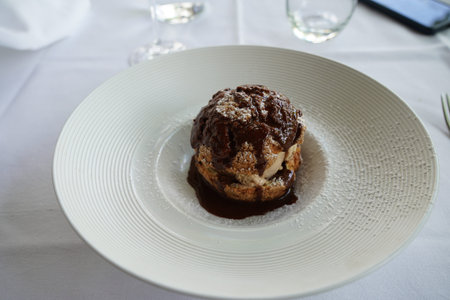 A Profiterole, French choux pastry covered in a rich chocolate sauce