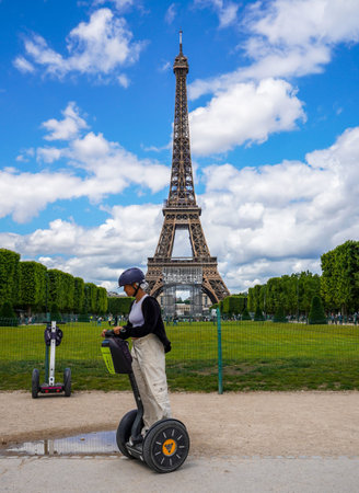 PARIS, FRANCE - JUNE 6, 2022: Tourist visiting the city near the Eiffel Tower during guided Segway...