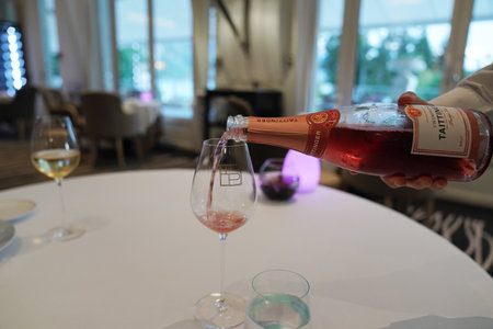 EPERNAY, FRANCE - SEPTEMBER 24, 2022: Bartender pouring Taittinger rose champagne into glassのeditorial素材