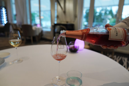 EPERNAY, FRANCE - SEPTEMBER 24, 2022: Bartender pouring Taittinger rose champagne into glassのeditorial素材