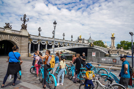 PARIS, FRANCE - JUNE 2, 2022: Tourists enjoying a guided bicycle tour with stop near Alexandre III bridge in Paris, Franceのeditorial素材