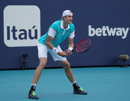 MIAMI GARDENS, FLORIDA - MARCH 30, 2022: Professional tennis player John Isner of USA in action during 2022 Miami Open quarter-final doubles match at the Hard Rock Stadium in Miamiのeditorial素材