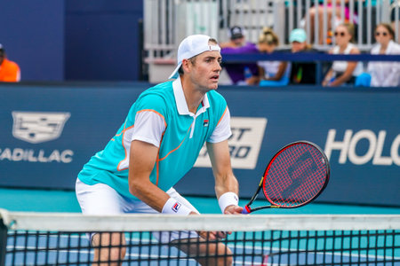MIAMI GARDENS, FLORIDA - MARCH 30, 2022: Professional tennis player John Isner of USA in action during 2022 Miami Open quarter-final doubles match at the Hard Rock Stadium in Miamiのeditorial素材