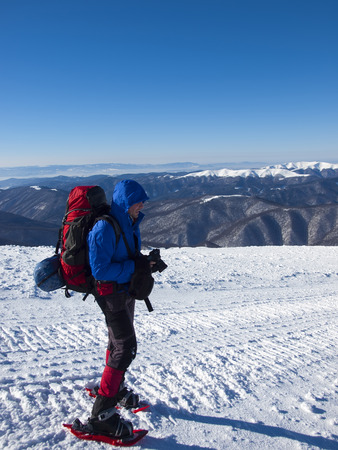 The man in snowshoes is in the mountains.の写真素材