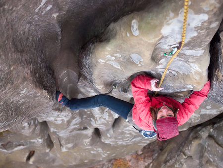 A young climber climbs on the vertical wall.