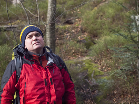 The man with the backpack goes through the woods and looking forward.の写真素材