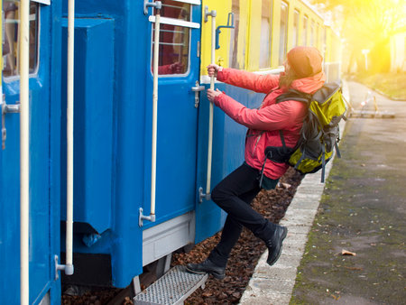 Girl with a backpack jumps out of the train while moving.の写真素材