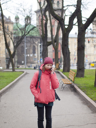 A young girl with a backpack talking on a cell phone.の写真素材