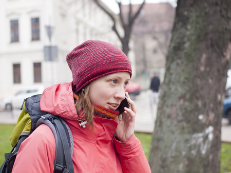 A young girl with a backpack talking on a cell phone.の写真素材