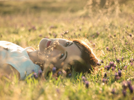 Girl lying in a field of flowers and smiling.の写真素材