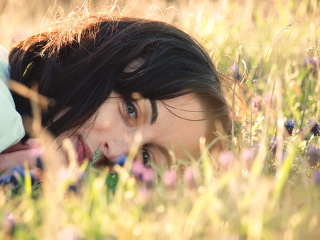 Girl lying in a field of flowers.の写真素材