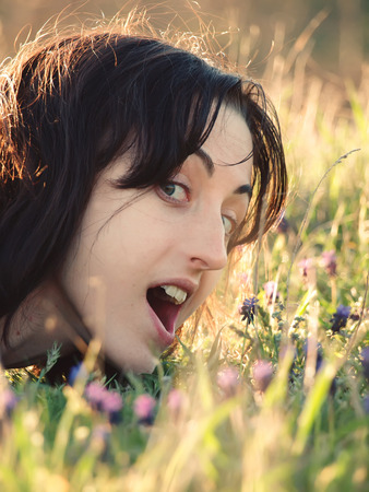 Girl lying in a field of flowers.の写真素材