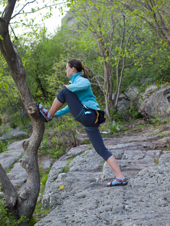 Girl doing stretching before class rock climbing and sports in nature.の写真素材
