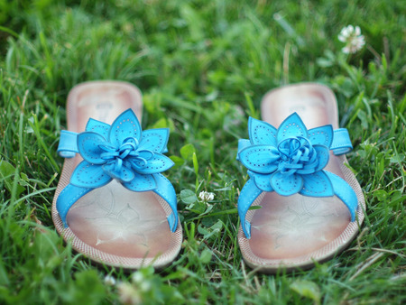 Blue summer shoes against the green grass.の写真素材