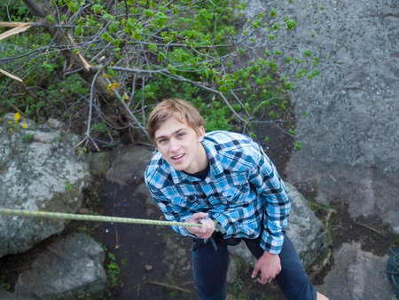 Man down on the rope after climbing on the rocks.の写真素材