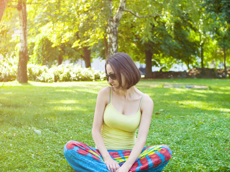 Young brunette with glasses relaxes in nature.の写真素材