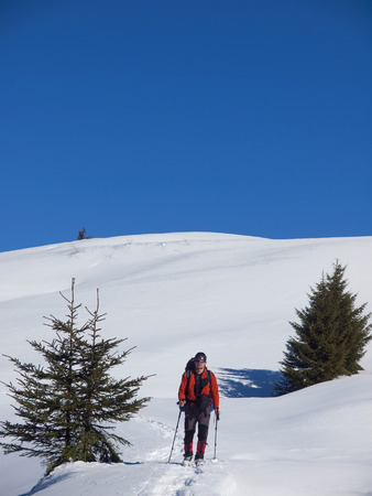 A man in snowshoes with a backpack and goes through the snow.の写真素材