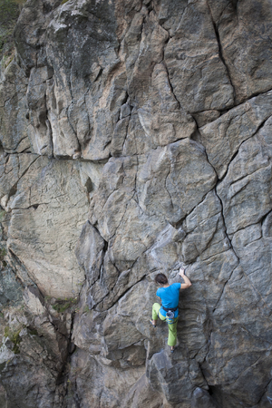 A young girl climbs the high wall to his goal.の写真素材