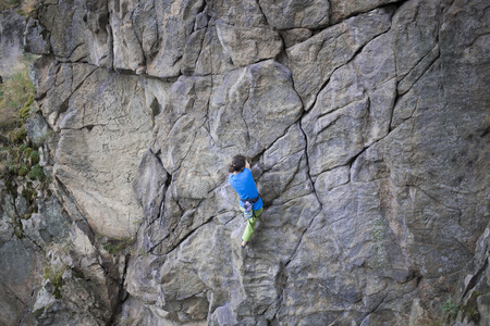 A young girl climbs the high wall.の写真素材