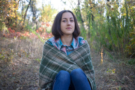 The girl wrapped the blanket rest on the nature.