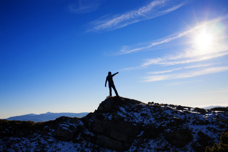 Silhouette climbers on the top of a high mountain.の写真素材