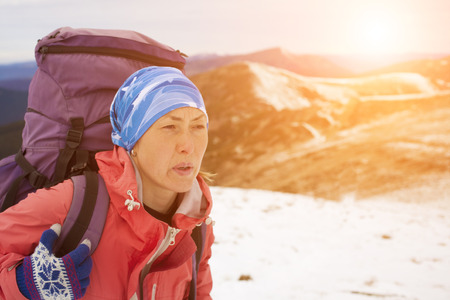 Girl with backpack is traveling in the mountains.の写真素材