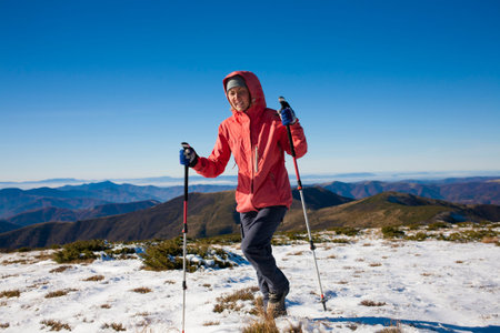 The girl walks through the snow in the mountains.