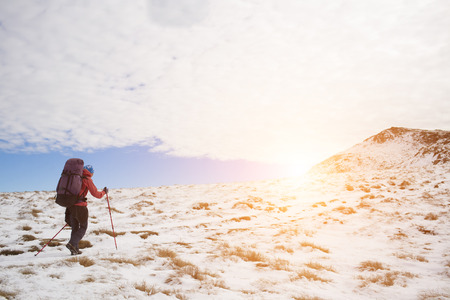 The girl with the backpack goes on a mountain trail.の写真素材