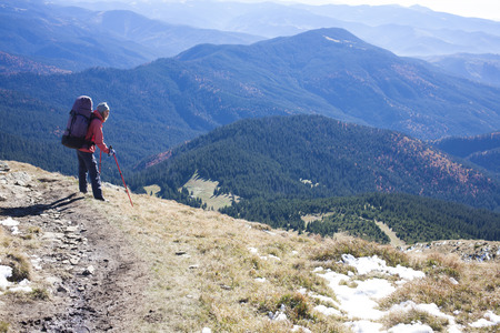 Tourist with backpack standing on a mountain.の写真素材