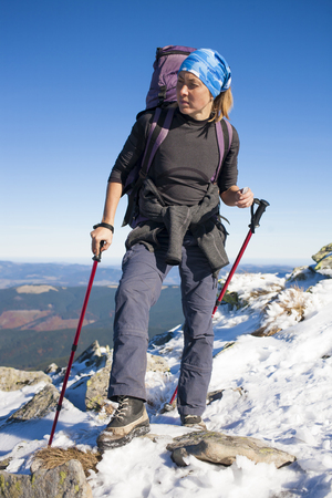 Girl with backpack standing on top of a mountainの写真素材