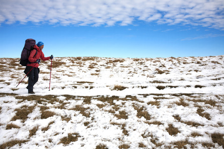 The girl goes through the snow in the mountains.の写真素材