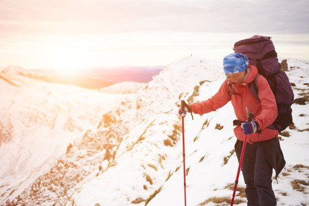 The girl with the backpack goes on a mountain trail.の写真素材