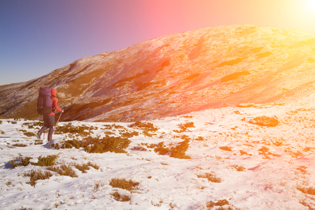 Climber with a backpack goes through the snow.の写真素材