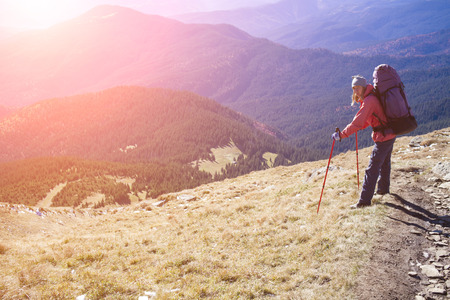 Tourist with backpack standing on a mountain.の写真素材