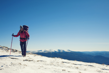 A young girl with a backpack goes through the snow.の写真素材