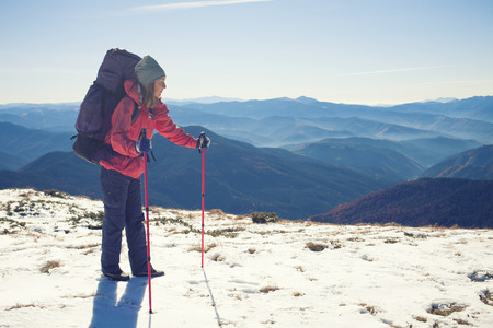 A young girl with a backpack goes through the snow.の写真素材