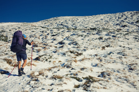 A young girl with a backpack goes through the snow.の写真素材