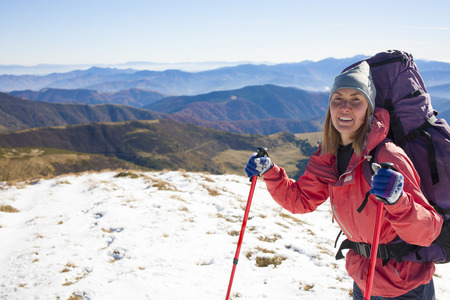 A young girl with a backpack on a background of mountains.の写真素材