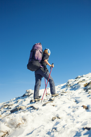 Climber with backpack is the snowy slope to his goal.の写真素材