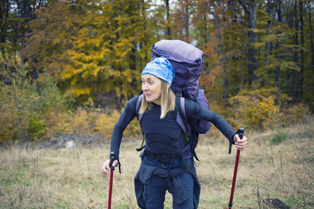 The girl with the backpack walking in the forest.の写真素材