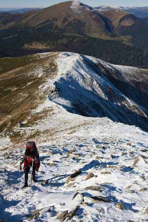 The girl with the backpack goes through the snow.の写真素材