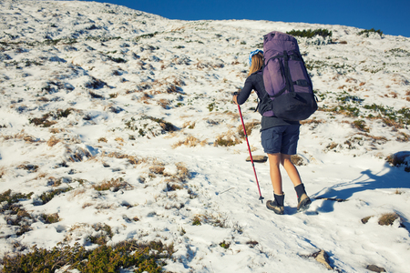A young girl with a backpack goes through the snow.の写真素材