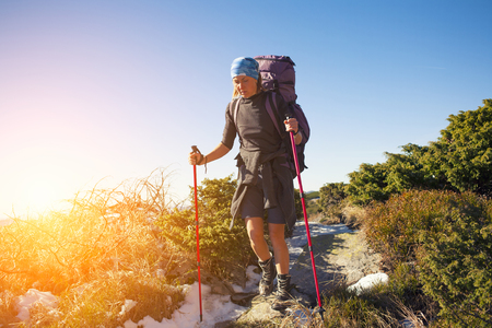 Girl with backpack is traveling in the mountains.の写真素材