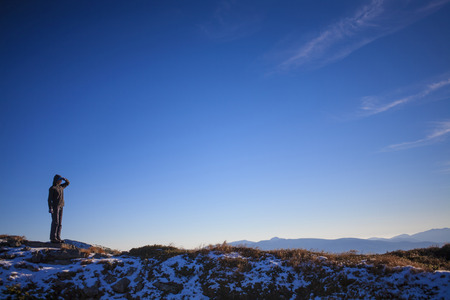 Silhouette girl climbers on the top of a high mountain.の写真素材