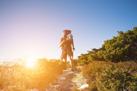 Girl with backpack is traveling in the mountains.の写真素材