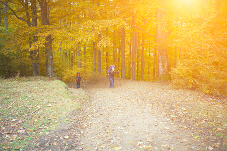 Two girls with backpacks coming through the forest.の写真素材