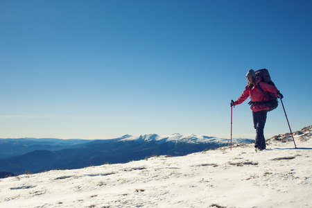 The girl with the backpack goes through the snow.の写真素材
